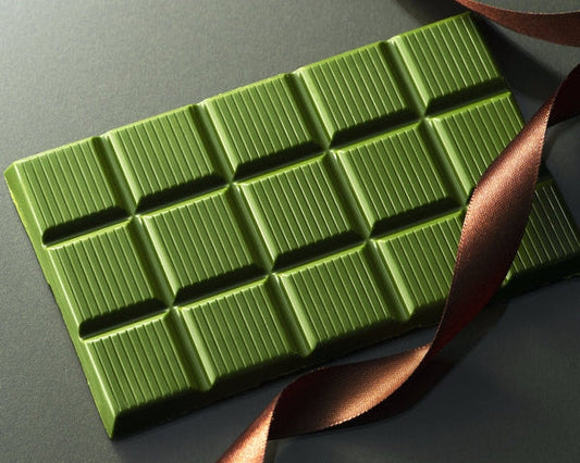 Premium Matcha White Belgian Chocolate atmospheric shot with brown ribbon and grayscale background